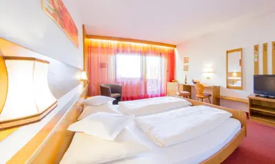 a hotel room with two beds and a television at Pension Lafod in Tirolo