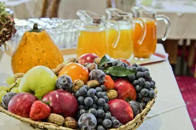 a basket of fruit on a table with jars of juice at Pension Lafod in Tirolo