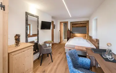 a hotel room with a bed and a table and chairs at Sporthotel Exclusive in San Vigilio Di Marebbe