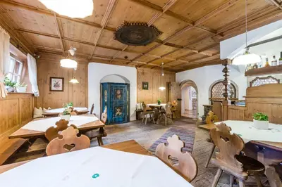 a dining room with wooden ceilings and tables and chairs at Sporthotel Exclusive in San Vigilio Di Marebbe