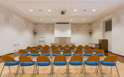 a conference room with chairs and a podium at Sporthotel Exclusive in San Vigilio Di Marebbe