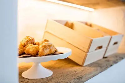 a plate of croissants on a table next to a box at Pension An Der Linde in Lagundo