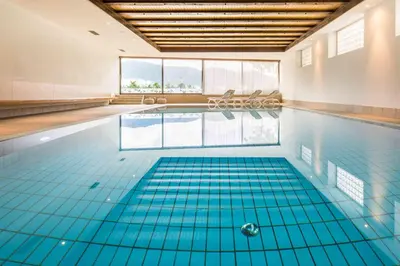 a swimming pool with blue tiles on the floor at Pension An Der Linde in Lagundo