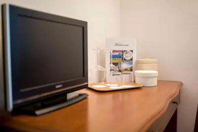 a television sitting on a wooden table with a box at Pension An Der Linde in Lagundo