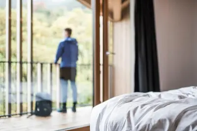 a man standing on a balcony looking out of a window at Alpinhotel Vajolet - Adults only in Tires