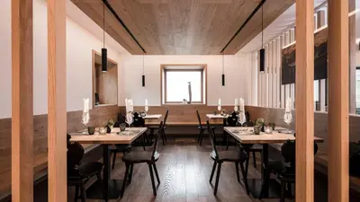 a dining room with tables and chairs and a window at Alpinhotel Vajolet - Adults only in Tires