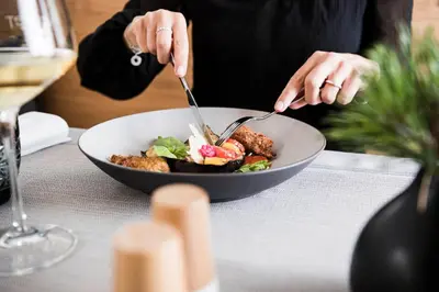 a person eating a bowl of food on a table at Alpinhotel Vajolet - Adults only in Tires