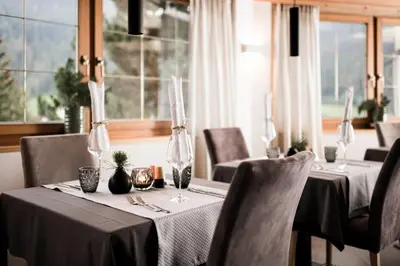 a dining room with two tables with black tablecloths and chairs at Alpinhotel Vajolet - Adults only in Tires