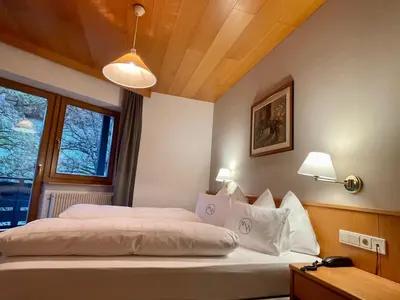 a bedroom with two beds and a window at Alpinhotel Vajolet - Adults only in Tires