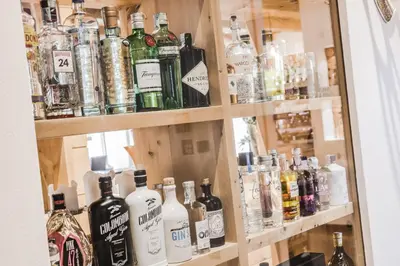 a display case with many bottles of alcohol at Hotel Chalet S - Dolomites Design - adults recommended in Selva di Val Gardena