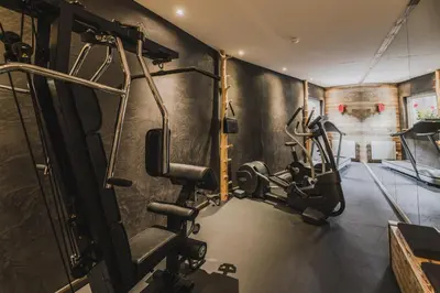 a gym with cardio equipment in a room at Hotel Chalet S - Dolomites Design - adults recommended in Selva di Val Gardena