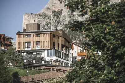 a building with a mountain in the background at Hotel Chalet S - Dolomites Design - adults recommended in Selva di Val Gardena
