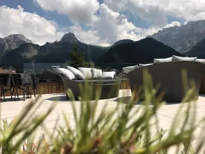 two chairs and a table with a view of mountains at Hotel Chalet S - Dolomites Design - adults recommended in Selva di Val Gardena
