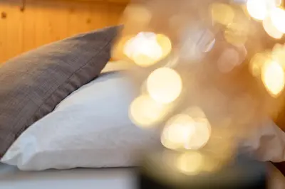 a bedroom with a bed with a wooden wall at Negritella Sweet Hotel in Ziano di Fiemme