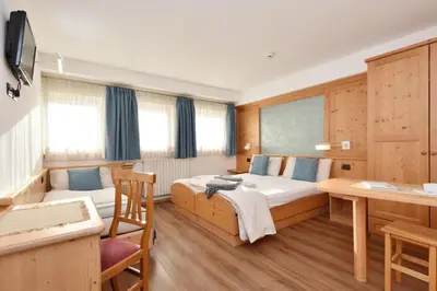 a small bedroom with a bed and a window at Negritella Sweet Hotel in Ziano di Fiemme