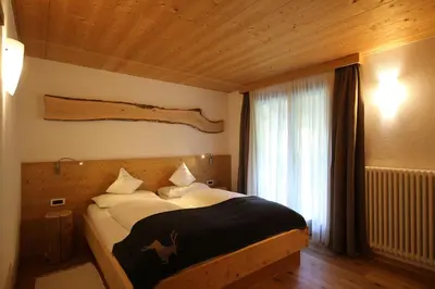 a bedroom with a bed with a deer painted on it at La Bercia Alpine Lodge & Spa in La Villa