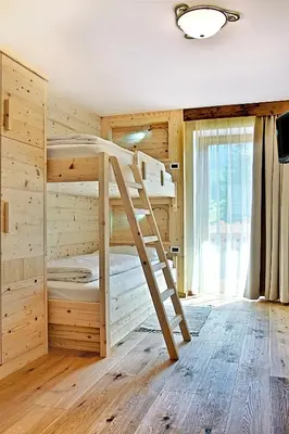 a bedroom with bunk beds in a log cabin at La Bercia Alpine Lodge & Spa in La Villa