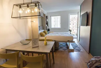 a room with a bed and a table and chairs at Stay COOPER l MAVIK Loft & Apartment in Bolzano