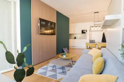 a living room with a blue couch and a table at Stay COOPER l MAVIK Loft & Apartment in Bolzano