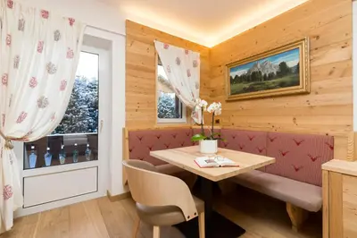 a dining room with a table and a window at Sporthotel Arabba in Arabba