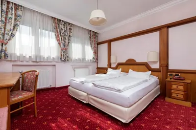 a bedroom with a large white bed and a desk and a table at Sporthotel Arabba in Arabba