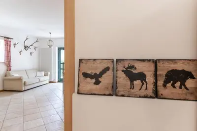 four paintings of animals on a wall in a living room at La Piccola Casa Verde in Canale San Bovo