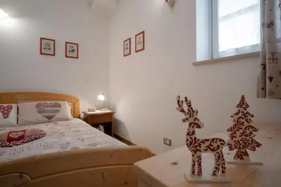 a bedroom with a wooden toy deer on a table at La Piccola Casa Verde in Canale San Bovo
