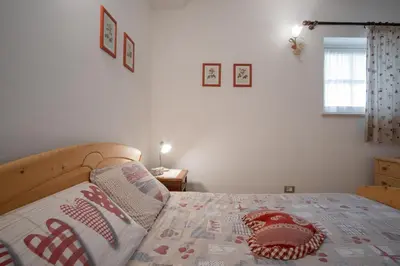 a bedroom with a bed with a quilt on it at La Piccola Casa Verde in Canale San Bovo