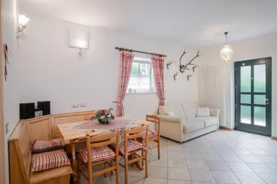 a living room with a table and chairs and a couch at La Piccola Casa Verde in Canale San Bovo