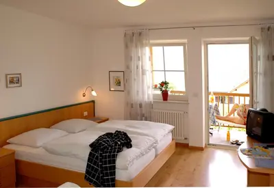 a bedroom with a bed with a robe laying on it at Residence Nesslerheim in Termeno