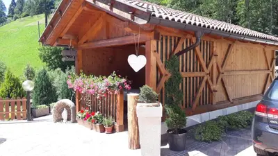 a wooden pavilion with flowers in a parking lot at HartlHof in Proves