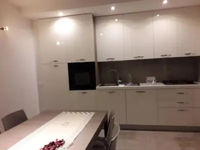 a kitchen with white cabinets and a table with chairs at HartlHof in Proves