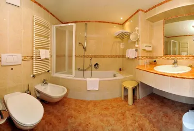 a bathroom with a toilet and a tub and a sink at Hotel Garni Concordia - Dolomites Home in Selva di Val Gardena