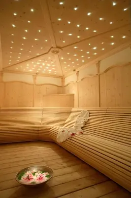 a large room with a bed and a bowl of flowers at Hotel Garni Concordia - Dolomites Home in Selva di Val Gardena