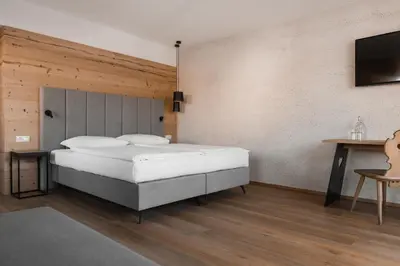 a bedroom with a bed and a flat screen tv at Hotel Gasthof Jochele in Falzes