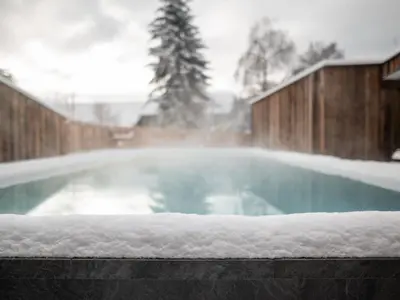 a swimming pool with snow on top of it at Hotel Gasthof Jochele in Falzes