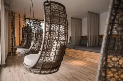 a living room with a row of hanging chairs at Hotel Gasthof Jochele in Falzes