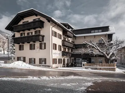a large building on a street with snow on the ground at Hotel Gasthof Jochele in Falzes