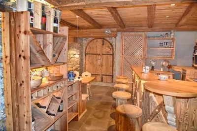 a kitchen with wooden walls and wooden tables and stools at Residence Blumenthalerhof in Lagundo