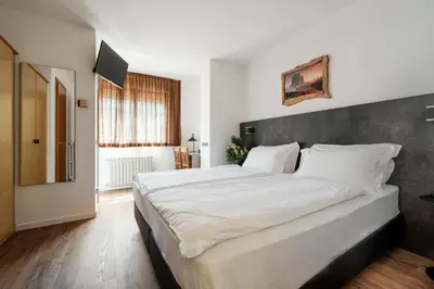 a bedroom with a large white bed in a room at Best Western Hotel Nevada in San Vito di Cadore