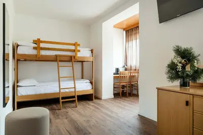 a small room with a bunk bed and a desk at Best Western Hotel Nevada in San Vito di Cadore
