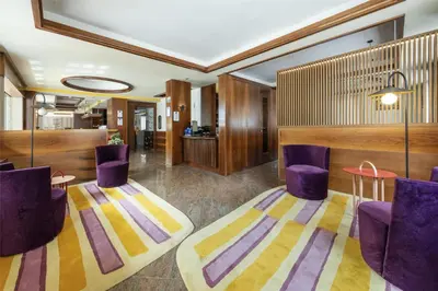 a lobby with purple chairs and a table at Best Western Hotel Nevada in San Vito di Cadore