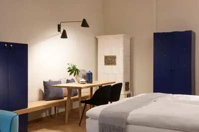 a bedroom with a table and a bed and blue cabinets at Arcade Apartments in Bolzano