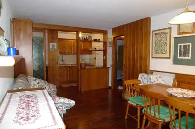 a living room with a table and a dining room at Condominio Le Marmotte in Selva di Cadore