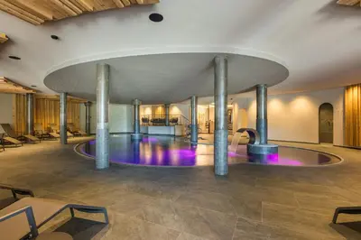 a pool in a room with columns and a fountain at Hotel Christoph in Valdaora