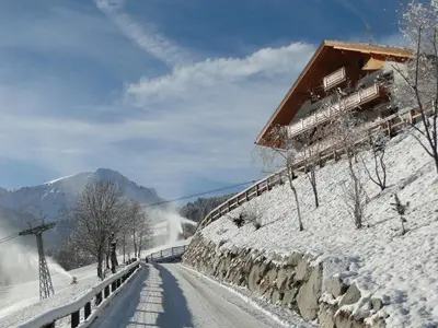 a road covered in snow next to a building at Residence Mühlegg in Valdaora