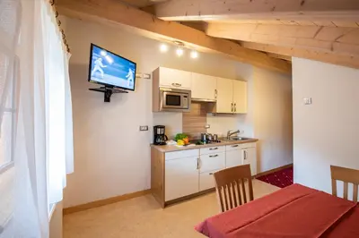 a small kitchen with a table and a tv on the wall at Residence Mühlegg in Valdaora
