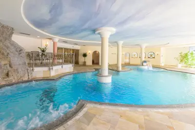 a large pool in a hotel with a cloud ceiling at Residence Mühlegg in Valdaora