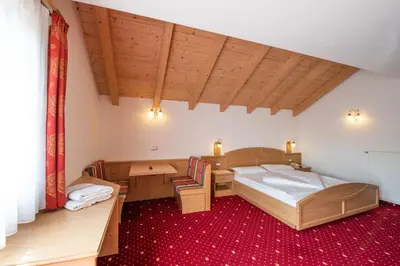 a bedroom with a bed and a table and chairs at Residence Mühlegg in Valdaora