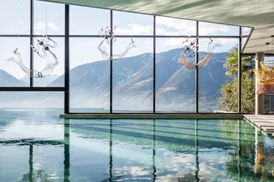 a house with a swimming pool with a mountain view at Hotel Rosengarten (Schenna Resort) in Schenna